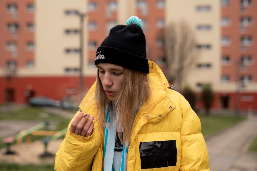 raper zibex w żółtej kurtce na tle bloku