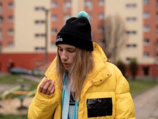 raper zibex w żółtej kurtce na tle bloku