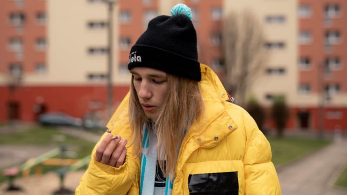 raper zibex w żółtej kurtce na tle bloku